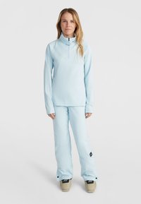 Helles blaues Ski-Outfit bestehend aus einem langärmligen Zip-Up-Oberteil und passenden Hosen, die einen bequemen Schnitt und eine weiche Textur aufweisen.