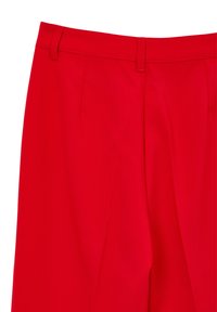 Helle rote maßgeschneiderte Hose mit Gürtelschlaufen, vorderen Falten und einer glatten Stoffoberfläche, von der Taille abwärts gezeigt.