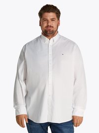 Camisa blanca de manga larga y botón, hecha de algodón, con un cuello clásico, que presenta un pequeño logo en el pecho y un corte relajado.