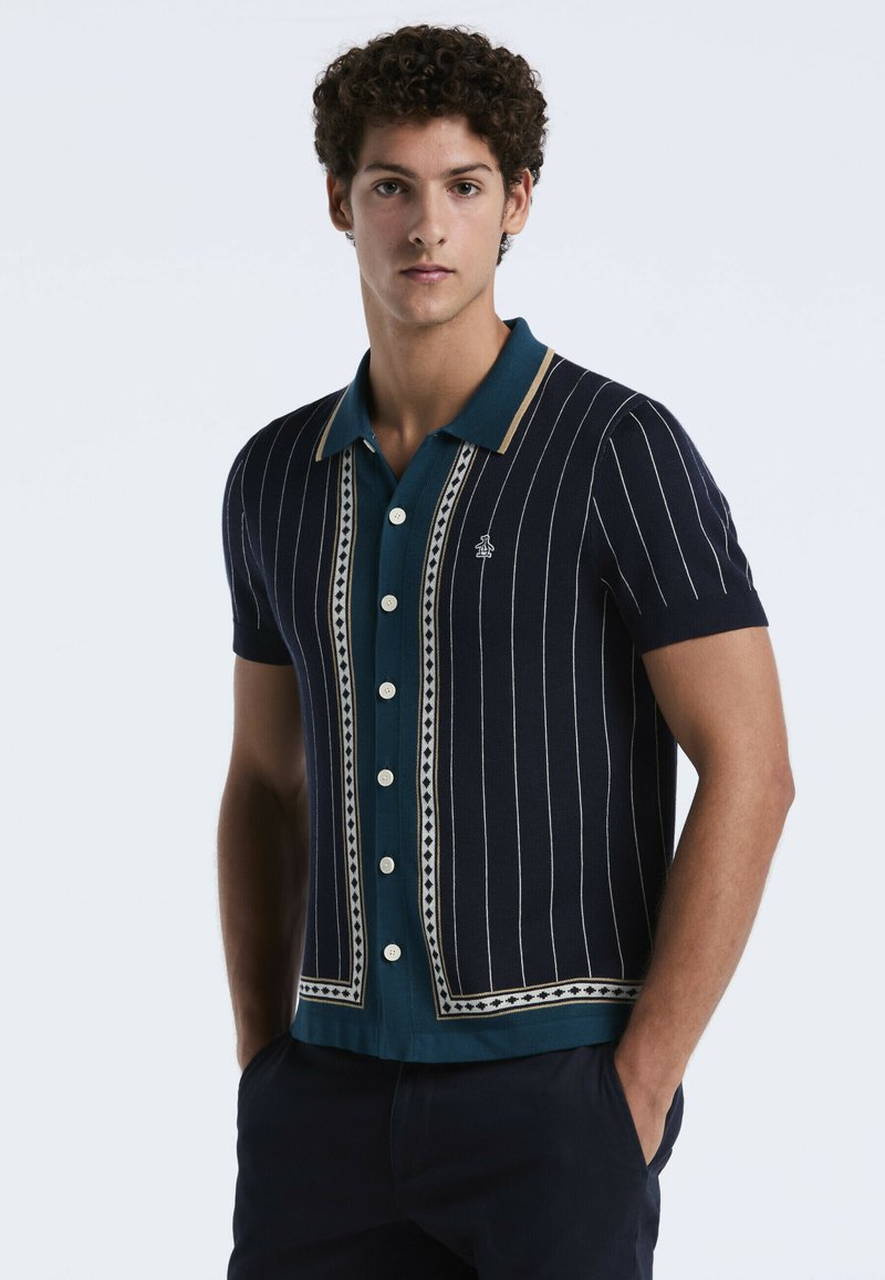 Marineblauw katoenen polo-shirt met korte mouwen, voorzien van verticale witte strepen, een teal kleurige kraag, een decoratief patroon en knopen aan de voorkant.