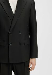 Doppeltknopf schwarzer Blazer aus glattem Stoff, mit flachen Taschen, schwarzen Knöpfen und strukturierter Schultergestaltung.