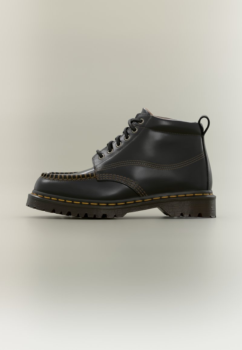 Black leather ankle boot with yellow stitching, lace-up front, thick ridged sole, and pull tab at the heel, shown in left profile on neutral background.