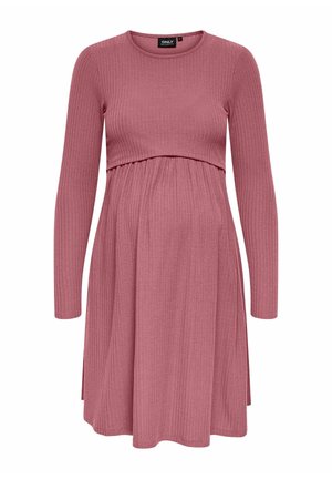 Materniteitsjurk in ribstof, zachte roze kleur, lange mouwen, aansluitende bovenkant met geplooide taille, uitlopende rok onder de buik.