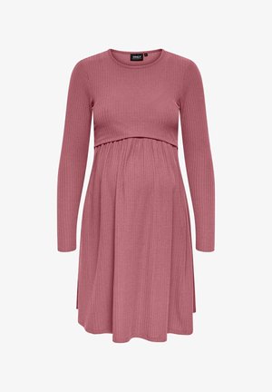 Sukienka ciążowa z prążkowanej tkaniny, w delikatnym różowym kolorze, z długimi rękawami, dopasowaną górą z marszczoną talią oraz rozkloszowanym dołem poniżej brzuszka.