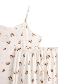 Zestaw kremowych piżam składający się z topu na ramiączkach i szortów, oba z powtarzającym się wzorem wiewiórek i niebieskich kwiatów. Miękki materiał bawełniany.