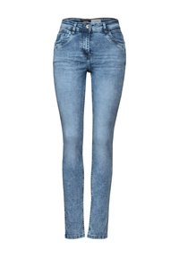 Jeans ajustados de color azul claro, hechos de denim, con una cintura de altura media, cinco bolsillos y un ligero desgaste en toda su superficie que añade textura.