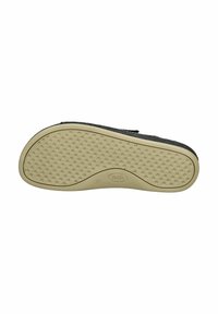 Zwarte schoenzool met een gestructureerde beige rubberen onderkant, voorzien van kleine ronde gripjes en een subtiel logo in het midden.