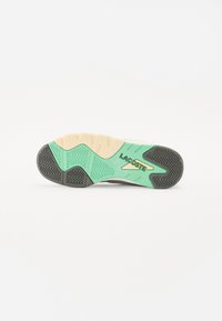 Shoe sole featuring a mint green and beige rubber design with zigzag patterns and textured grip; "LACOSTE" branding in green.