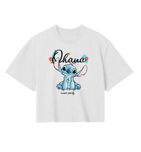 Biała koszulka z niebieską postacią kreskówkową Stitchem siedzącym pod napisem "Ohana" ozdobionym kwiatami oraz napisem "means family" poniżej.