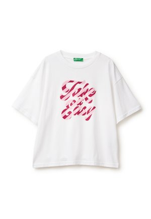 T-shirt en coton blanc à manches courtes, avec un imprimé rayé rose portant le texte "Take it Easy" centré sur le devant.