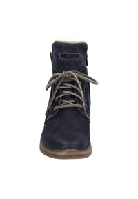 Botte cheville bleu marine en cuir texturé, avec des lacets gris et un col en fourrure douillette. Présente des coutures contrastées et une semelle brun clair.