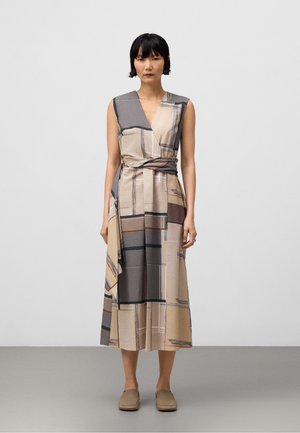 Robe portefeuille beige avec motif à carreaux géométriques ; sans manches ; tissu texturé ; lien à la taille ; longueur au genou. Chaussures marron à enfiler.