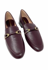 Mocassini in pelle bordeaux con una texture liscia, caratterizzati da una fibbia in metallo color oro e cuciture lungo i bordi.