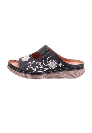 Black slip-on sandal with beige floral embroidery, thick textured sole, and cushioned interior.