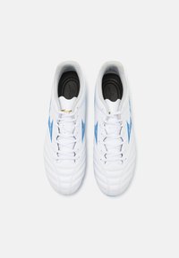 Zapatillas blancas con acentos azules y parte superior de cuero texturizado, con un collar ligeramente acolchado y cordones para un ajuste seguro.