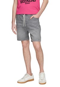 Szare dżinsowe szorty z elastycznym paskiem i sznurkiem, dwoma bocznymi kieszeniami oraz swobodnym krojem. Zestawione z białymi sneakersami na gumowej podeszwie.