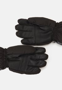 Black gloves featuring a leather palm and a soft fabric top. They have a gathered wrist for snug fit and protection against cold.