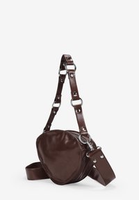 Bolso bandolera de imitación cuero marrón con forma redondeada, que presenta un acabado texturizado y detalles en plata en la correa.