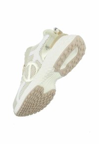 Witte en beige sport sneaker met een bovenwerk van mesh, een ronde neus, een gestructureerde zool, en opvallende branding op de hiel. Lichtgewicht ontwerp.