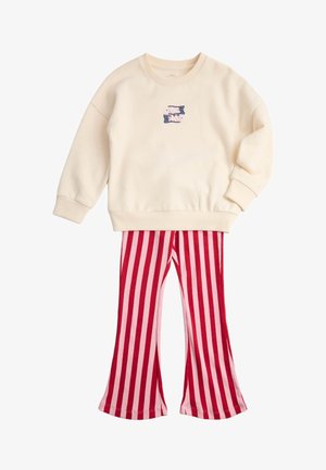 Cremefarvet sweatshirt med lange ærmer med lille grafik og røde og pink vertikalt stribede flare bukser til børn.