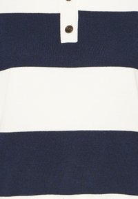 Polo rayé bleu marine et blanc avec une texture côtelée, un col uni avec bandes et une patte de boutonnage à trois boutons marron.