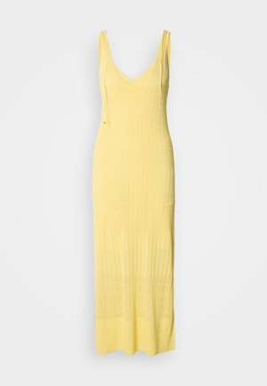Rochie maxi tricotată de culoare galben deschis, cu decolteu în V și bretele subțiri ajustabile. Prezintă un model texturat cu secțiuni alternante.