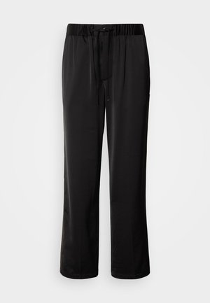 Pantalones negros de corte holgado con cinturilla elástica y cordón ajustable. Tela suave con detalles en las costuras laterales, sin bolsillos.