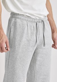 Grå bomulds-sweatpants med elastisk taljebånd og snøre, med sidelommer og en blød, struktureret stofoverflade.