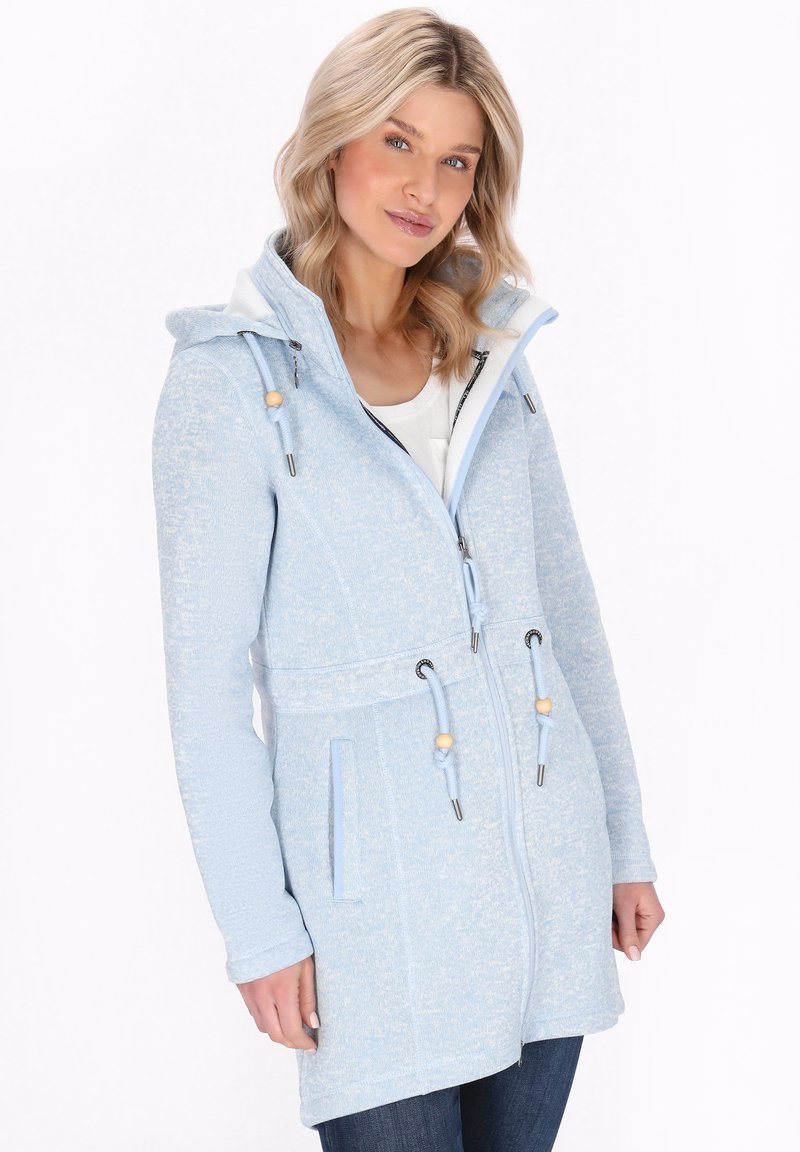 Šviesiai mėlyna tekstūruota zip-up džemperis su gobtuvu, raišteliais, mediniais akcentais ir dviem priekinėmis kišenėmis. Papuoštas subtiliu raštu.