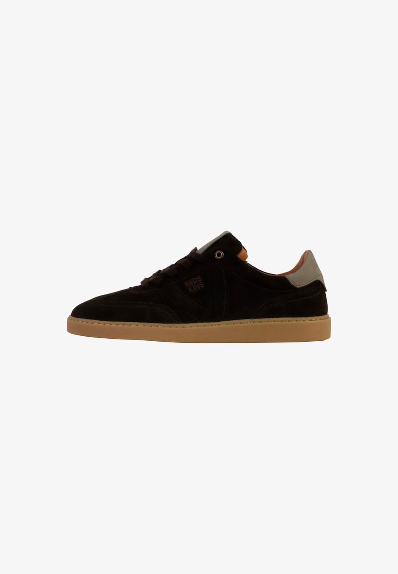 Sneaker in suede nera con suola in gomma marrone, dotato di lacci scuri, dettagli sul tallone grigio chiaro e un logo di lato. Vista laterale.