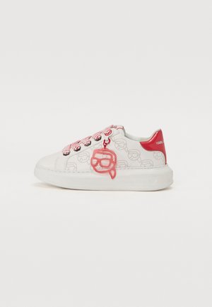 Fehér sneaker, rajzos mintával, piros kiegészítőkkel és rózsaszín szemüveg charm-mal. Texturált cipőfűzőkkel és vastag gumitalppal rendelkezik.