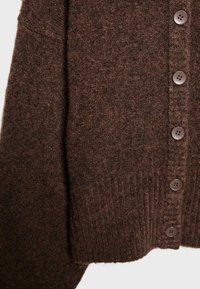 Hnědý pletený svetr s žebrovaným lemem a zapínáním na knoflíky vpředu. Látka má jemný strukturovaný povrch a pět odpovídajících knoflíků.