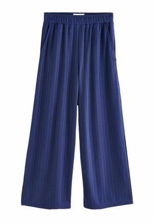 Pantaloni ampi di colore blu navy con texture a coste, dotati di vita elastica e tasche laterali per una funzionalità aggiuntiva.