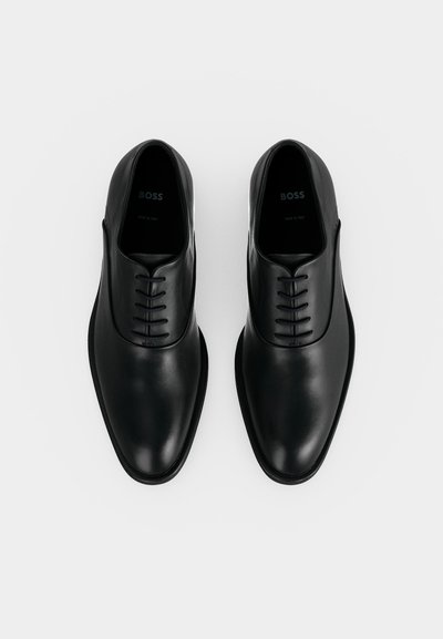 Мъжки официални обувки от черна кожа с закрито връзване, марка "BOSS", снимани отгоре на бял фон.