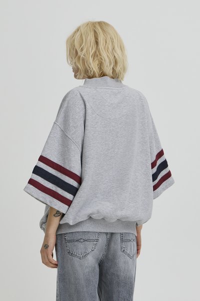 Grå oversize sweatshirt med vida ärmar som har vinröda och marinblå ränder. Ribbad krage och midjeband. Avslappnat tyg, ledig passform.