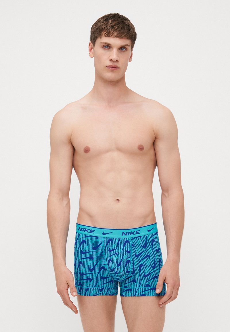 Nike boxershorts i blått med ett vågmönster. Mjukt, elastiskt material med en bred midjeband som visar Nike-loggan i kontrasterande blått.