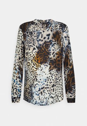 Bluzka z długim rękawem z marszczoną górą i mieszanym wzorem zwierzęcym w czarnych, brązowych, białych i niebieskich tonach na jasnym tle.