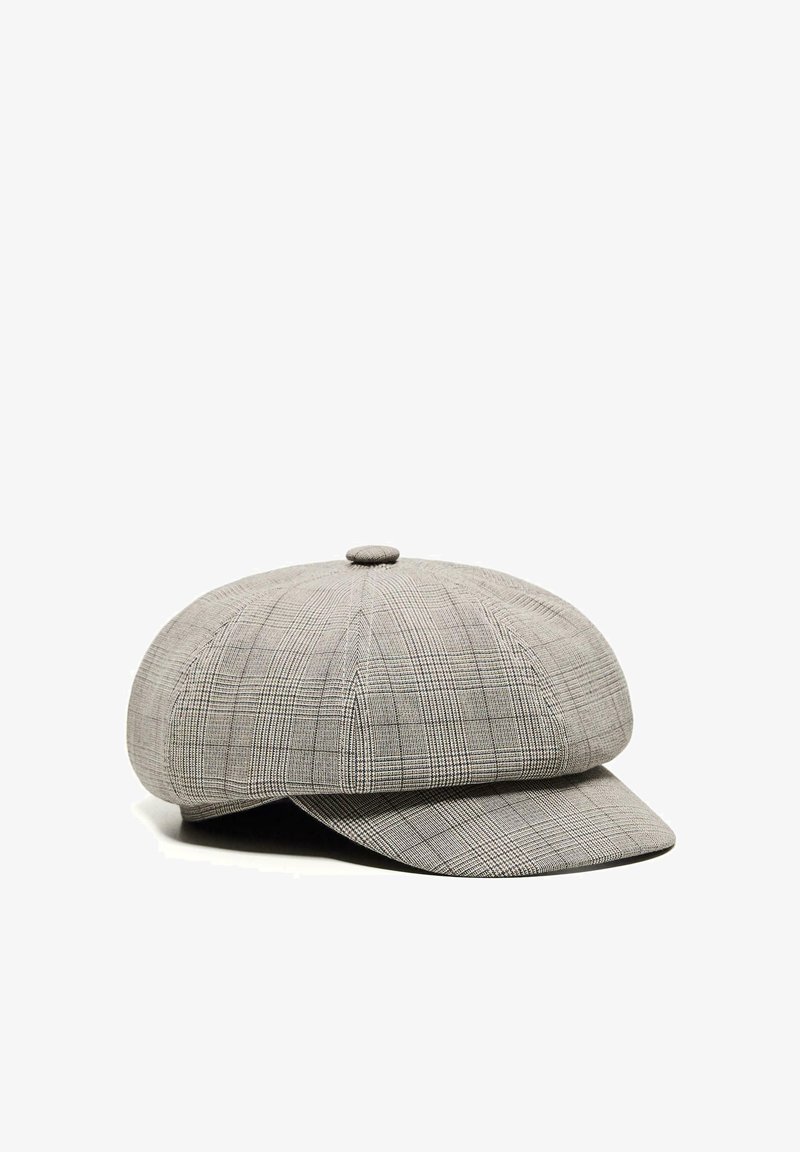 Casquette gavroche à carreaux gris avec un bouton rond sur le dessus et une courte visière avant, présentée sur un fond blanc.