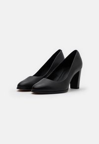 Chaussures à talons hauts en cuir noir avec une finition lisse, un bout pointu et un talon épais, présentant un design minimaliste sans ornements.