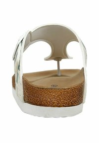 White sandal with a textured brown cork sole, featuring a strap design and a smooth footbed. The back has an open design and minimal hardware.