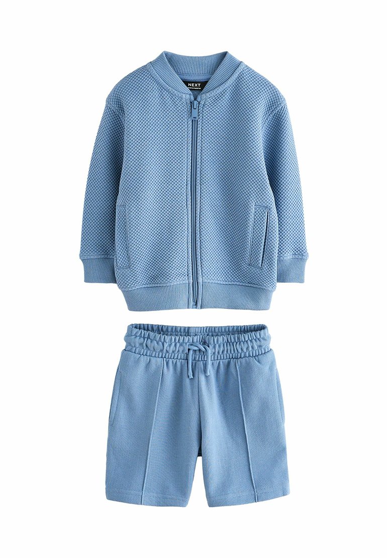 Himmelblaues Zweiteiler-Outfit mit einer strukturierten Zip-Jacke mit Taschen und passenden Shorts mit elastischem Bund und seitlichen Nähten.