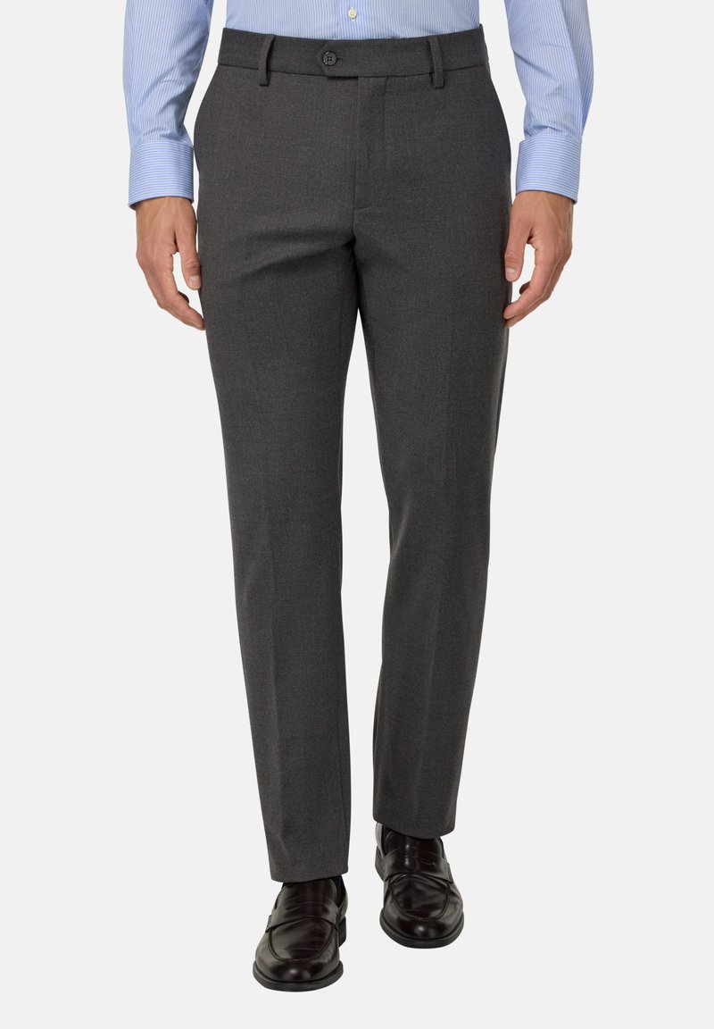 Pelēki piegriezti bikses ar gludu tekstūru, plakanu priekšpusi un vienu pogu aizdari. Saskaņots ar spīdīgiem melniem apaviem un gaiši zilu kreklu.