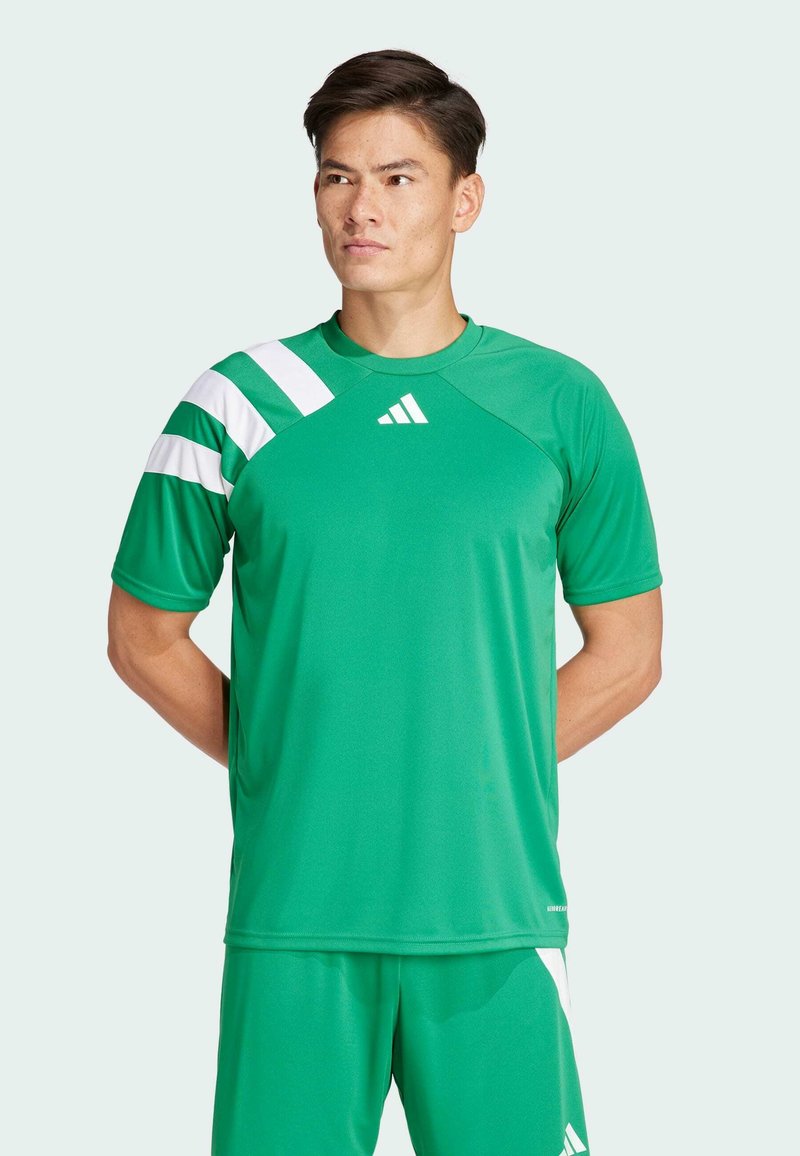 Roheline sportlik shirt lühikeste varrukatega, millel on valged diagonaalsed triibud ja logo. Valmistatud siledast, hingavast kangast.