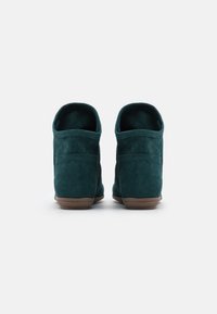 Teal ruskindsstøvler til anklerne med en rund form, lave hæle og ingen lukninger. Blød tekstur og minimal syning på siderne.