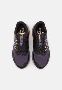 Fialové sportovní boty s prodyšným síťovaným svrškem, černými akcenty a reflexními detaily. Mají polstrovanou podešev a šněrovací systém.