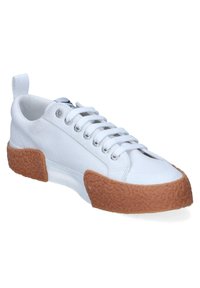 Sneaker bianca in tela con punta rotonda, chiusura con lacci, occhielli argentati e suola in gomma marrone testurizzata. Caratterizzata da un anello in tessuto sul tallone.