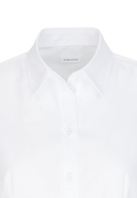 Vit skjorta med krage, som har knappar framtill. Tillverkad av slät tyg, designad med en klassisk passform och en krispig textur.