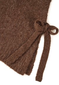 Pruun kootud riietus, millel on pehme ja karvane tekstuur; ühelt poolt on seotud lipsu detail ja ebaühtlane alläär.