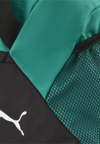 Zwarte en teal rugzak met een gemarmerde mesh zak, een gladde stofaccent en een prominent weergegeven wit logo.