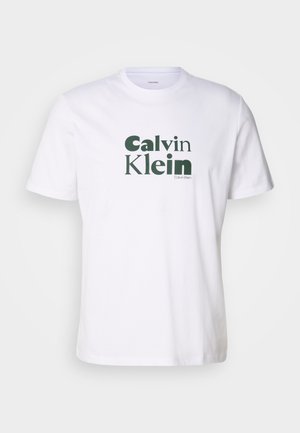 Balta medvilnė marškinėliai su žaliu "Calvin Klein" logotipu, atspausdintu ant priekio. Trumpomis rankovėmis, apvaliu kaklu ir standartinio kirpimo.